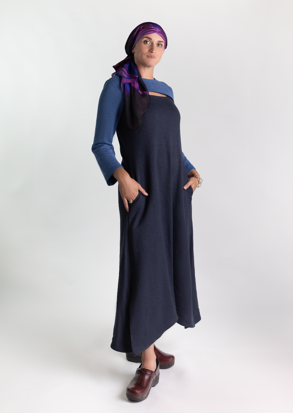 Woman in a cozy stylish dress that is chest port accessible for infusions. Wearing a silk headscarf