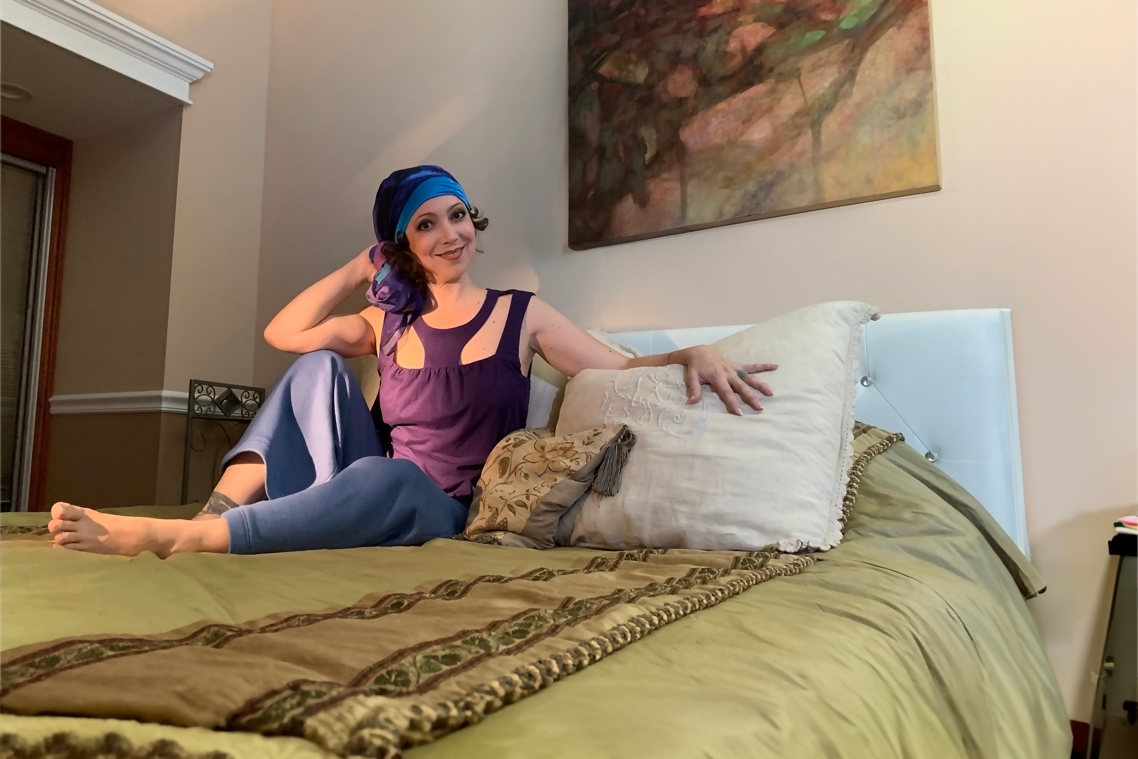 beautiful happy woman, wearing medically accessible adaptive wear garments, sitting on a bed