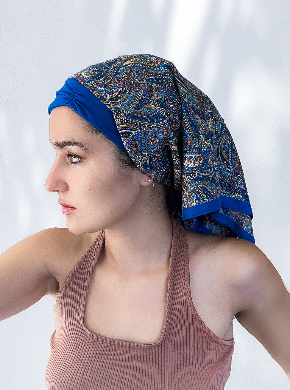 Beautiful woman wearing a blue paisley headscarf designed specifically for those dealing with hair loss