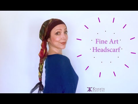 A woman in a blue blouse shows us how to wear and tie the exquisite Krysalis Kouture Fine Art Headscarf.  It can be styled and worn in over 20 different ways